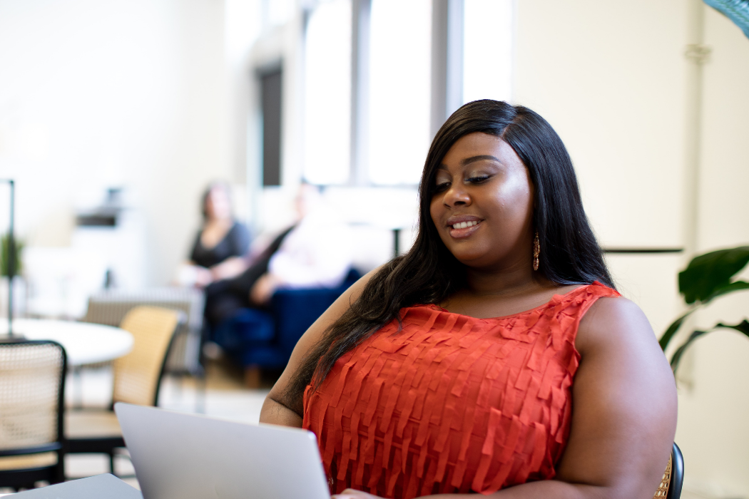 Woman working on her laptop in a large open room