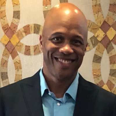 Charles Phillips headshot in front of an artistic background.