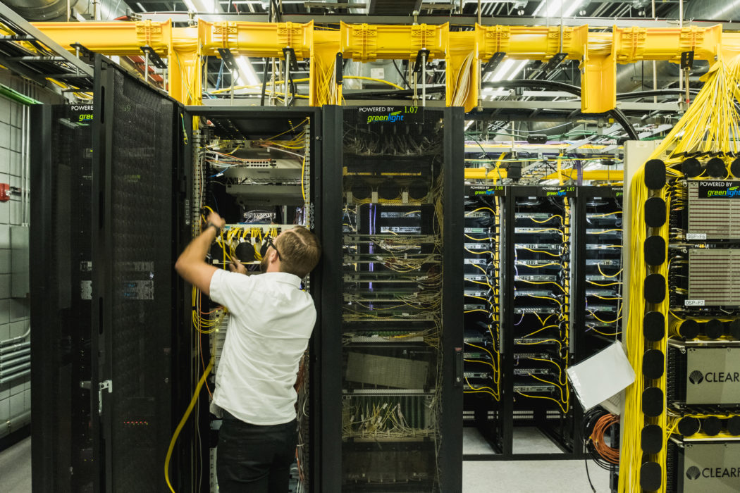 Someone working on a larger server in a warehouse