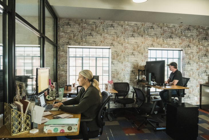 people working together in an office space on computers