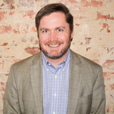 Jeff Navin headshot in front of an exposed brick wall.