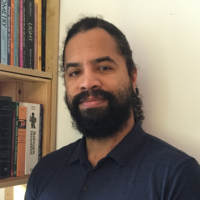 John Hall headshot in front of a book case