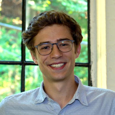 Myles Kamisher-Koch headshot in front of a window.