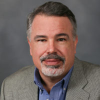 Mark Beliveau headshot in front of a gray background.
