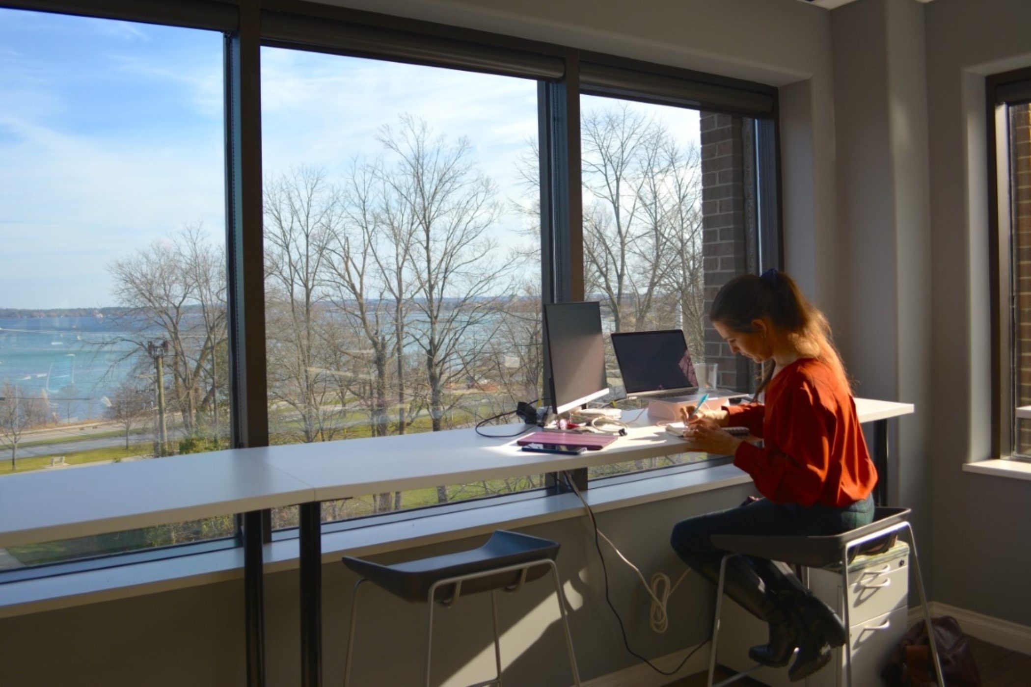 A person working at a computer with a view of the water in Traverse City