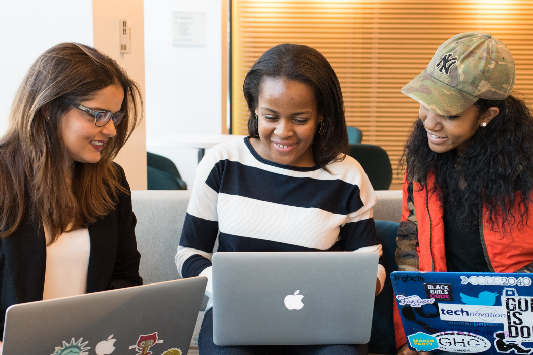 Three people close together looking at their laptops and working