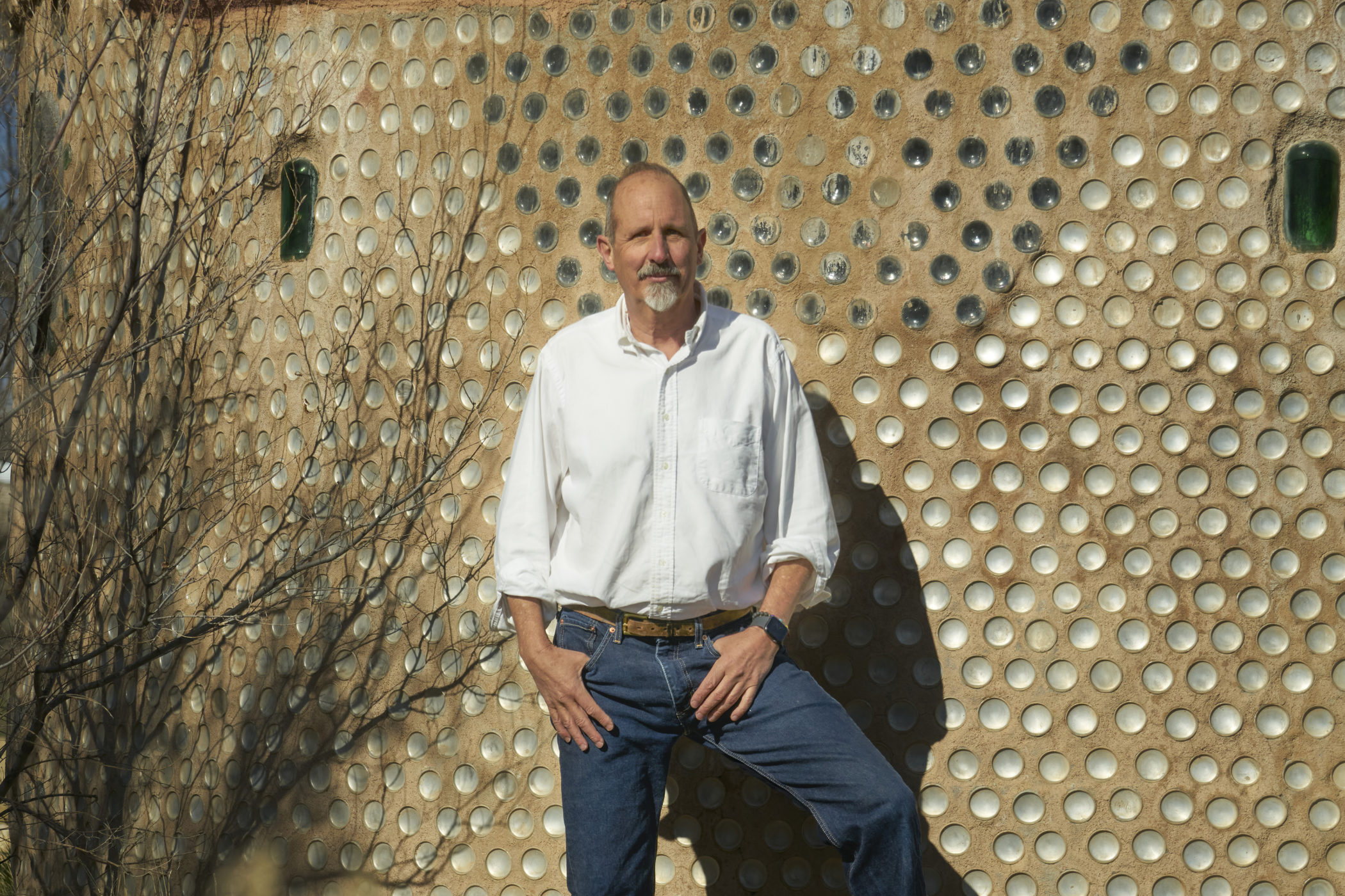 Marko Schmitt stands next to his earthship home