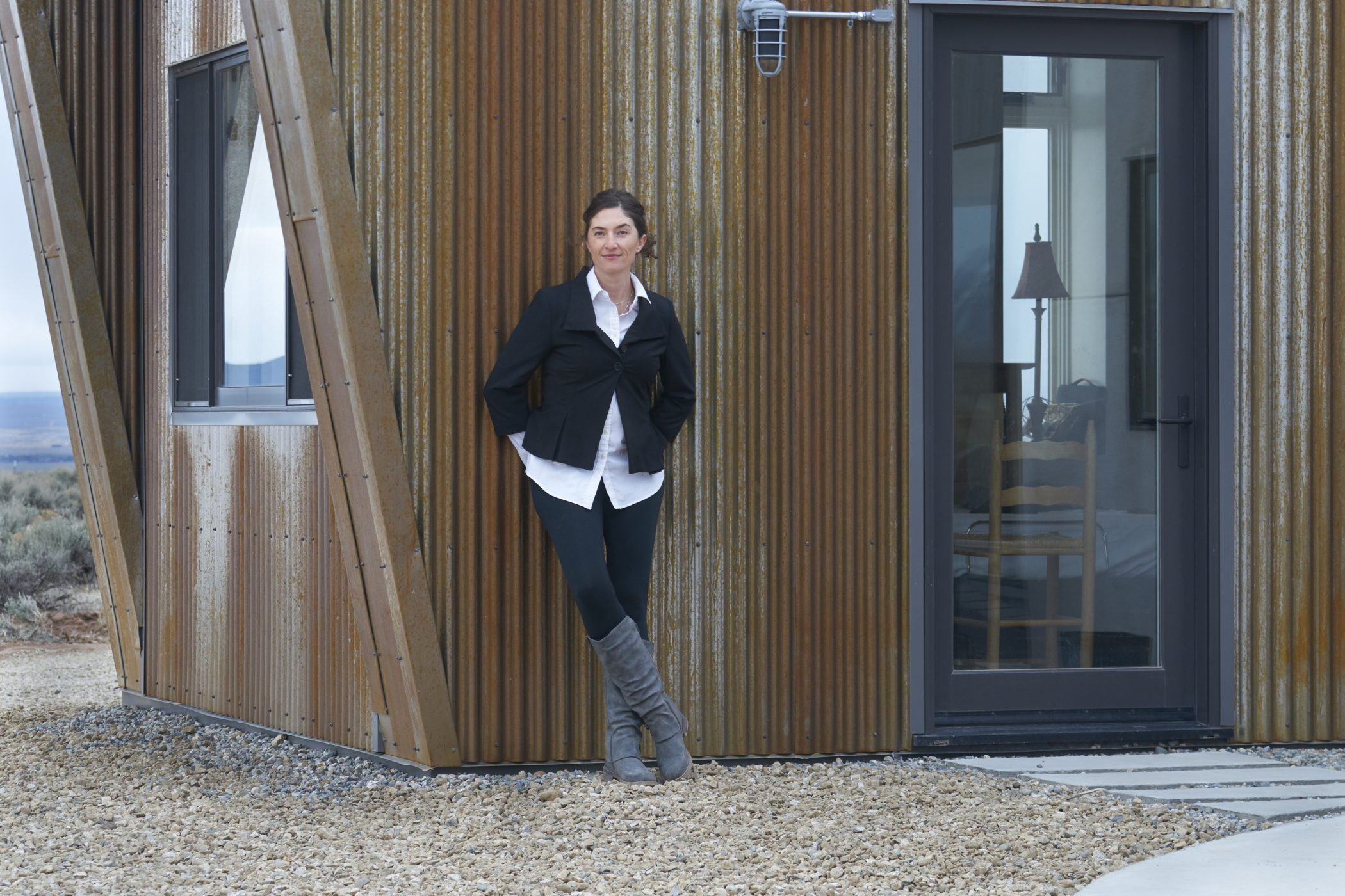 Melissa Lind leans against the outside of her home