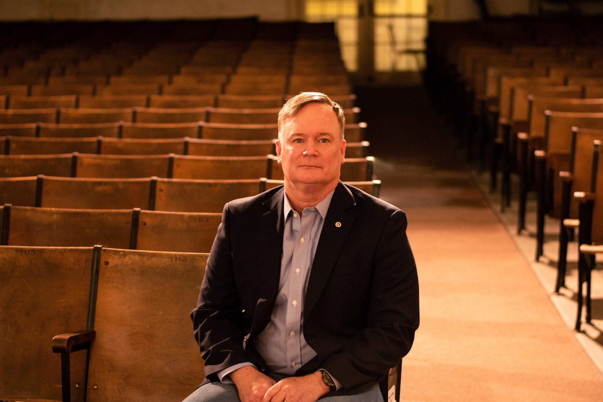 Rick Johnson sits in an empty auditorium