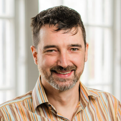 Chris Rowe headshot in front of a window