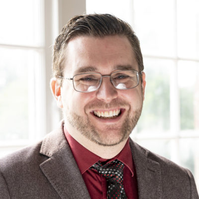 Matthew Rogers headshot in front of a bright window