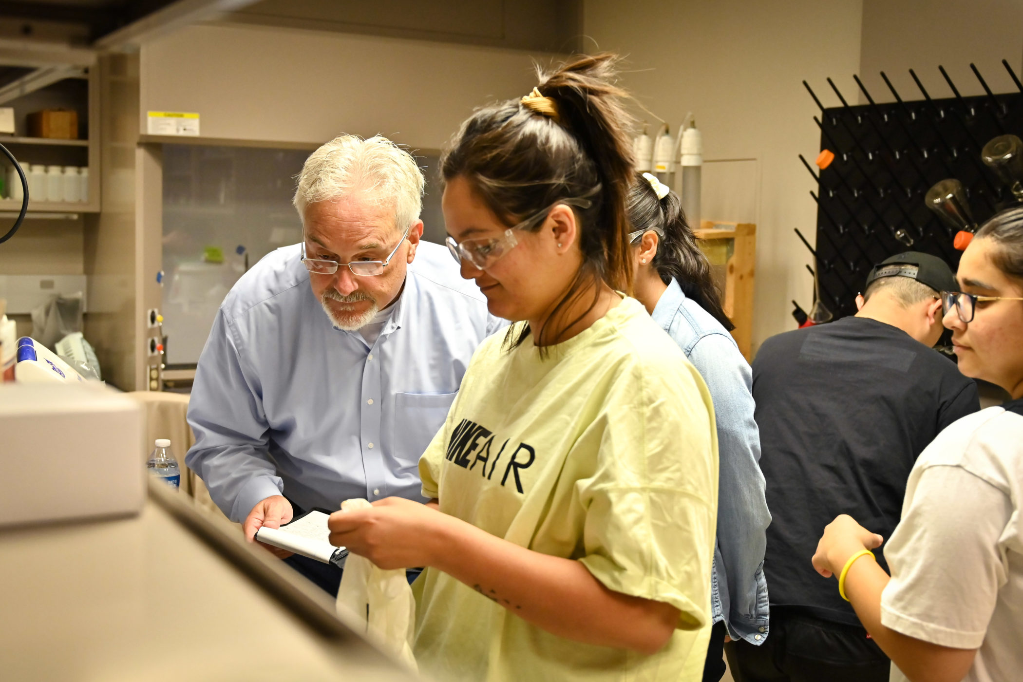 Guy Sewell examines students' work in a lab at ECU