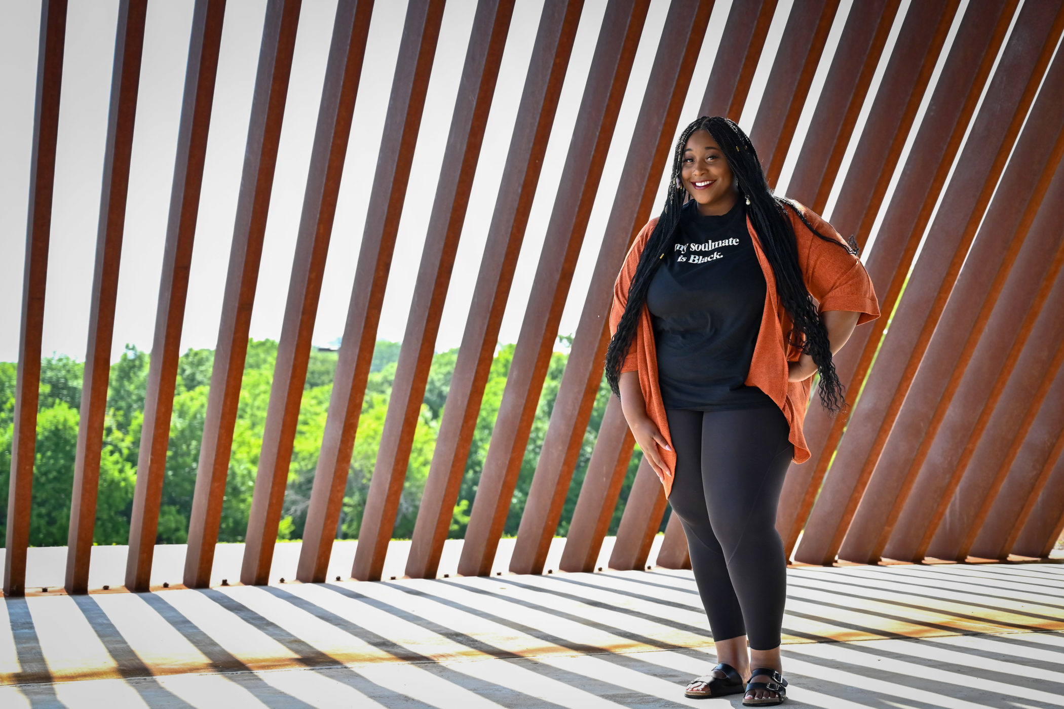 Amber Ransom is photographed standing in the shade of an art installation