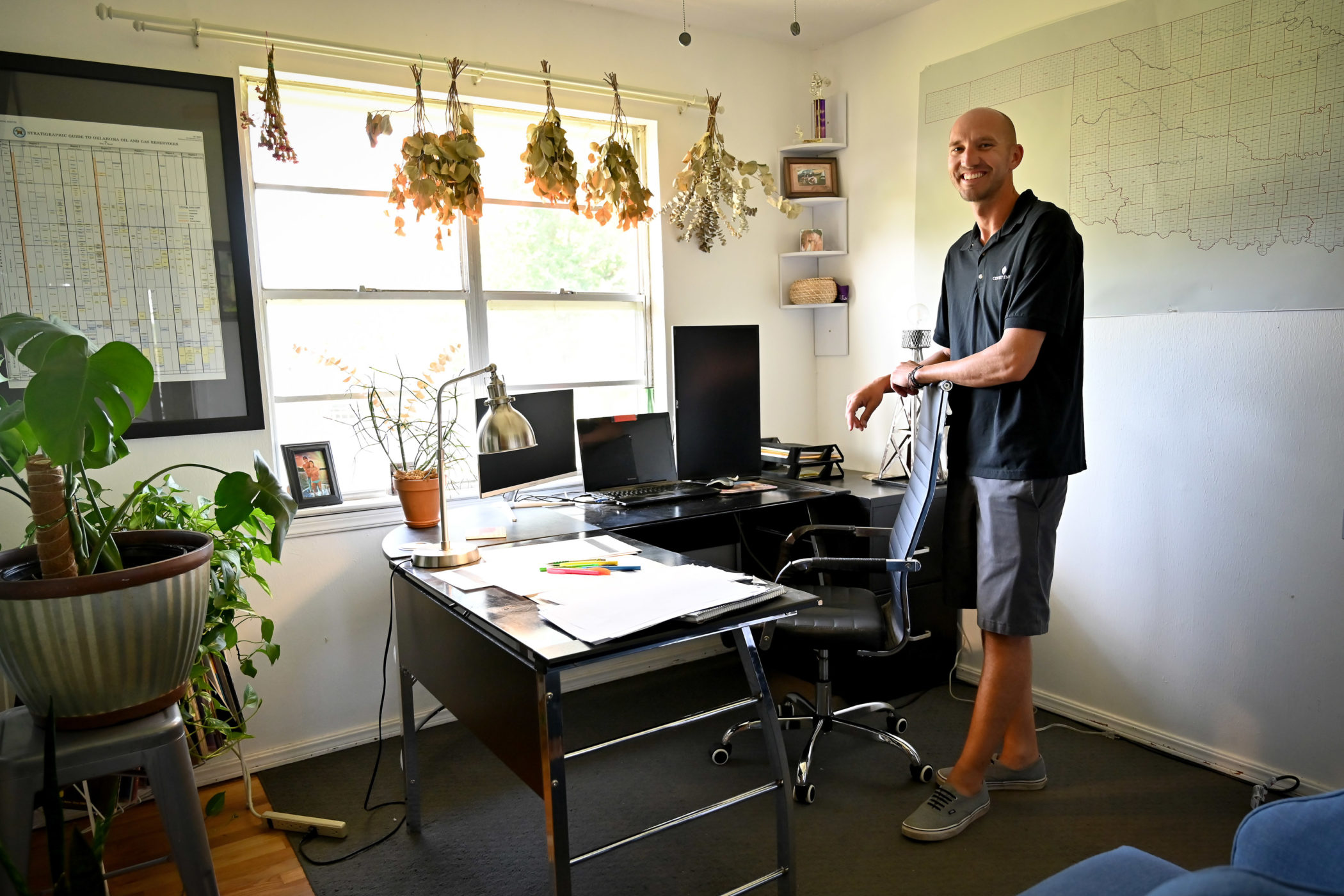 Cody Tucker stands behind the desk in his home office.