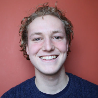 Camden Blatchly headshot in front of a red background