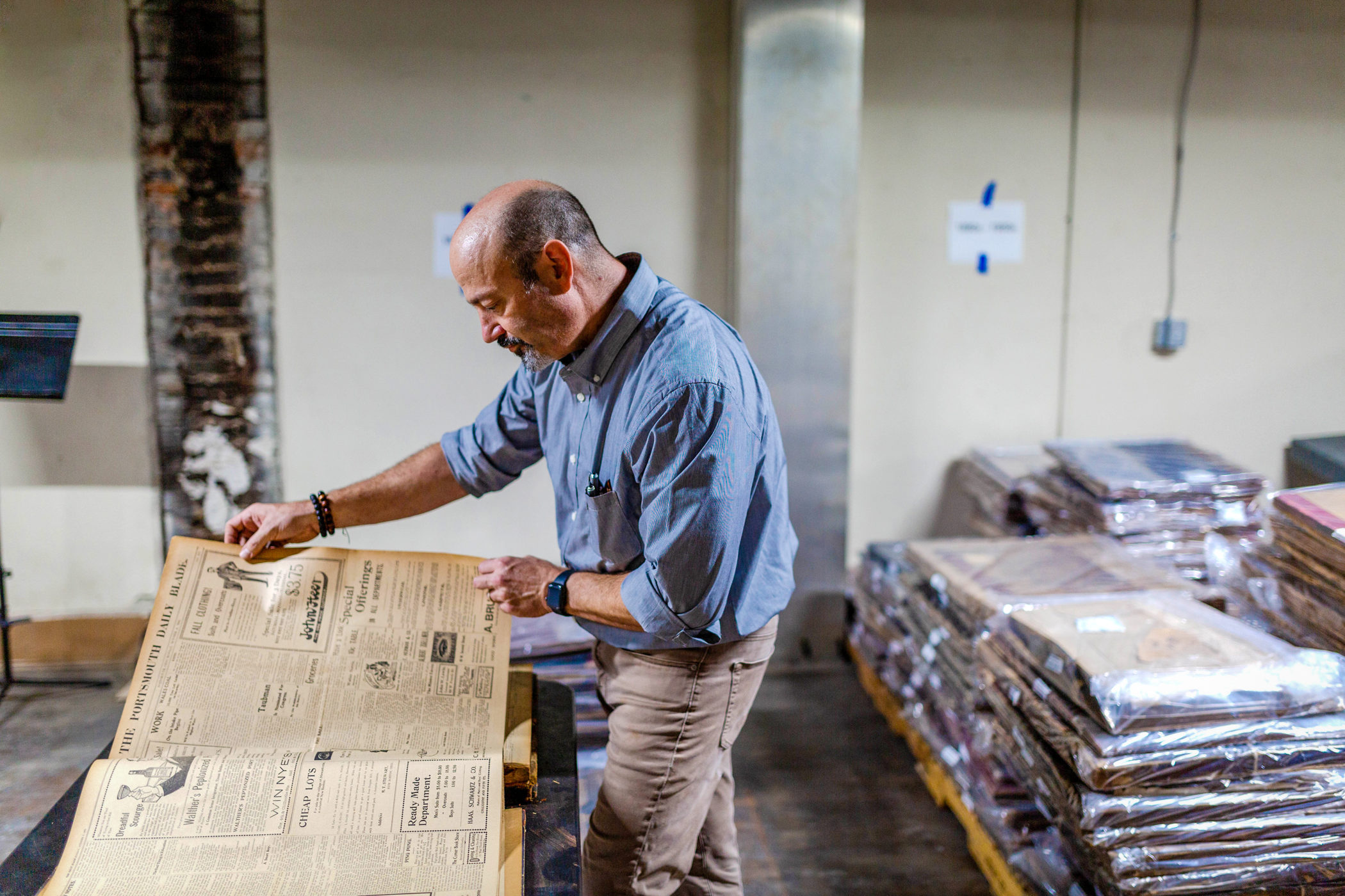 Andrew Feight leafs through newspaper archives