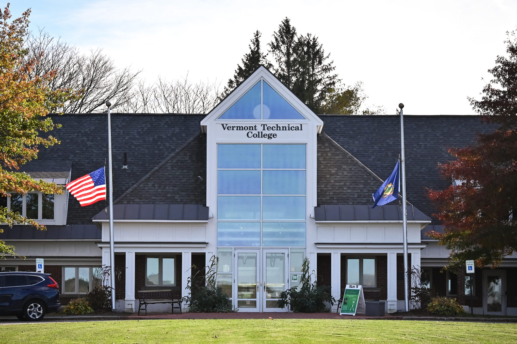 Flags fly at half-staff in front of the main administrative building of Vermont Technical College.