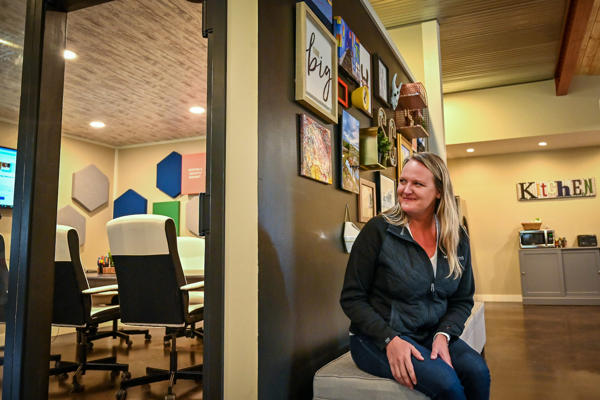 Renee Sievers sits on a bench in the Sievers Creative office