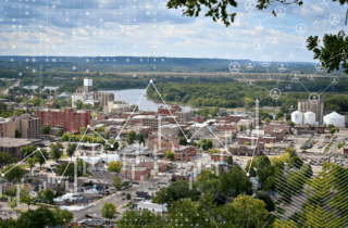 Aerial image of Redwing, Minnesota with overlay of data symbols and graphs to depict the importance of data in rural planning.
